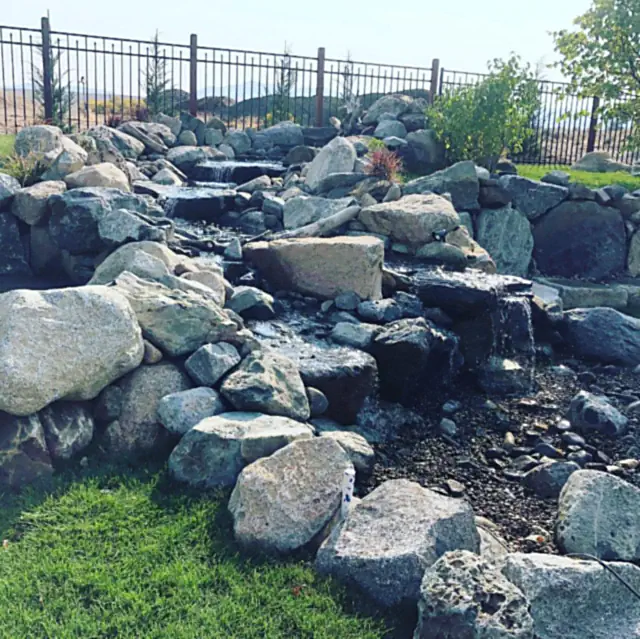Natural rock water feature with granite boulders and a stream bed